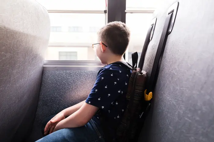 A boy looking out the window of a bus